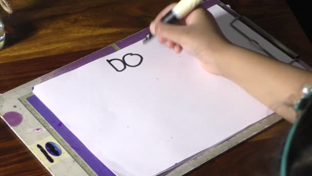 一个女孩在写东西 不要在黑板上和纸上担心 — 图库视频影像