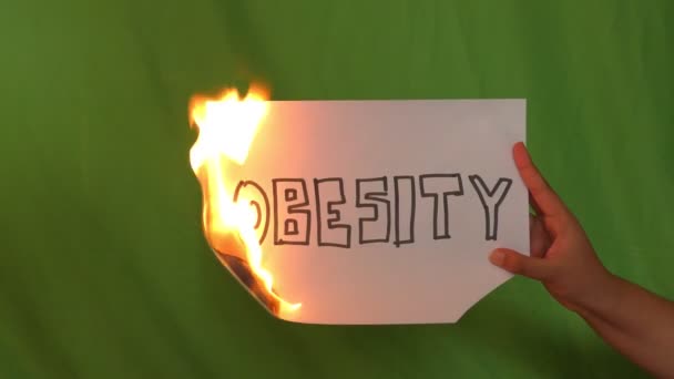 Hand Holds Burning Paper Obesity Text Word Green Screen — Stock Video