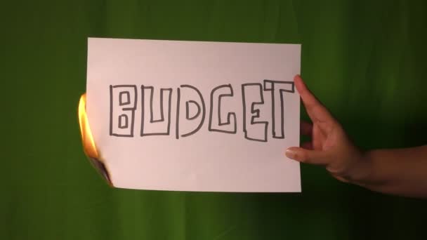 Een Hand Houdt Het Brandende Papier Met Budget Woord Het — Stockvideo
