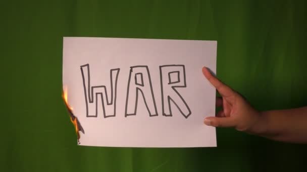 Рука Держит Горящую Бумагу Войны Разделить Текстовое Слово Нем Зеленом — стоковое видео