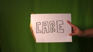 Bir el, yeşil ekranda özenle yazılmış kağıdın arkasını tutuyor..