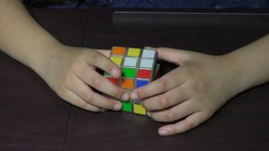 Onunla oynayan bir kızın elinde bozuk bir zeka küpü.