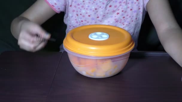 Ein Mädchen Öffnet Eine Obstschachtel Aus Plastik Zum Essen — Stockvideo