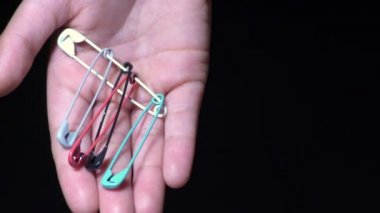 Bir kadın elinde birçok renkten çengelli iğne gösterir.