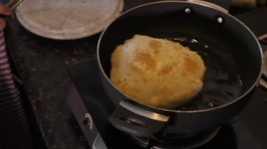 Isıtıcıda kızgın yağda bhature kızartıp kaşıkla çeviriyorum..