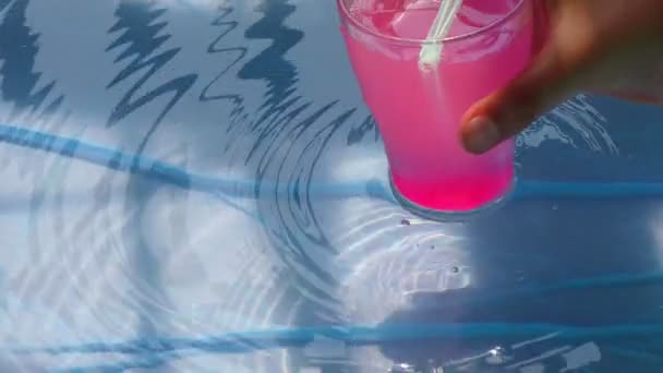 Eine Hand Legt Ein Pinkfarbenes Mocktail Getränk Poolwasser Und Buntes — Stockvideo