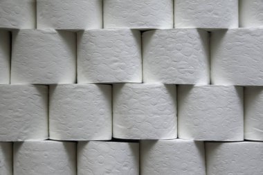 Üst üste dizilmiş tuvalet kağıdı rulolarının yakın görünümü, arkaplan