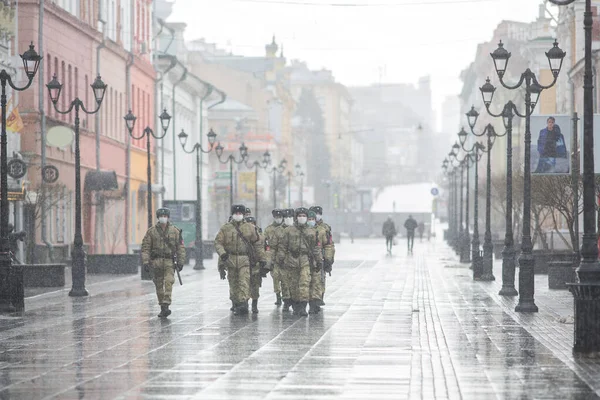 Nizhny Novgorod 'daki Bolshaya Pokrovskaya Caddesi' nde kar yağışı sırasında insanların Coronavirus 'taki karantina sırasında hareket etmelerini engelleyen bir askeri devriye (chovid-19)
