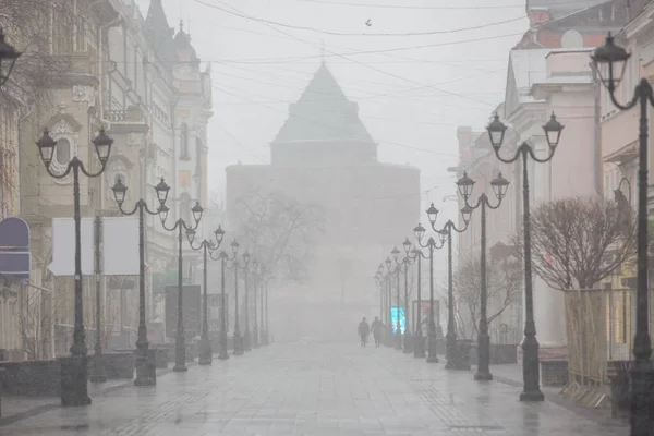 Nizhny Novgorod 'daki Bolshaya Pokrovskaya caddesinde kar yağışı sırasında yankılanan binaların yansımaları bahar güneşinde parke taşlarına yansıyan insanlar olmadan.