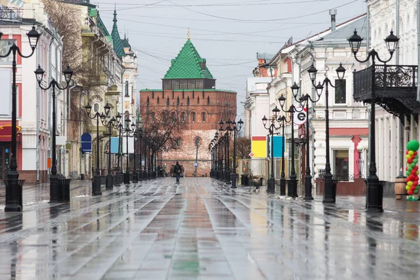 Nizhny Novgorod 'daki Bolshaya Pokrovskaya caddesinde kar yağışı sırasında yankılanan binaların yansımaları bahar güneşinde parke taşlarına yansıyan insanlar olmadan.