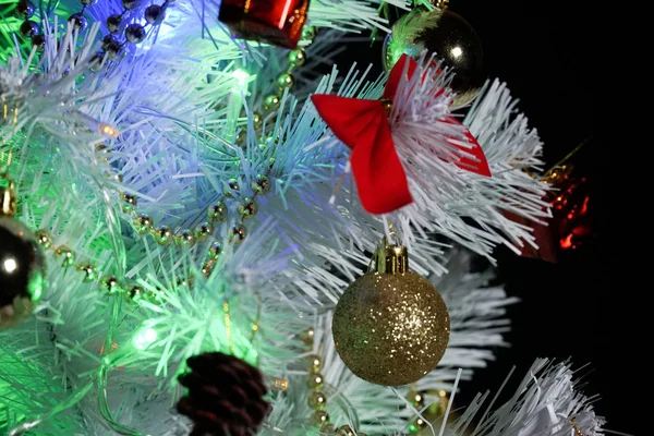 Süslü Noel ağacı. Karanlık bir arka planda Noel ağacı. Bir logo için boş yer. Renkli çelenk. Çok renkli ampuller. Karda beyaz Noel ağacı.