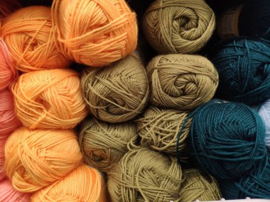 çok renkli iplik topları rafta yatıyor..