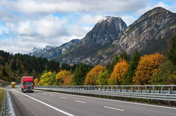 Czerwony samochód, jazda na autostradzie w Alpach. — Zdjęcie stockowe