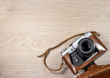 Eski film kamera üzerinde ahşap arka plan fotoğrafı bir kahverengi deri çanta.