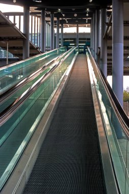 Bir cam muhafaza ile modern yürüyen merdiven.