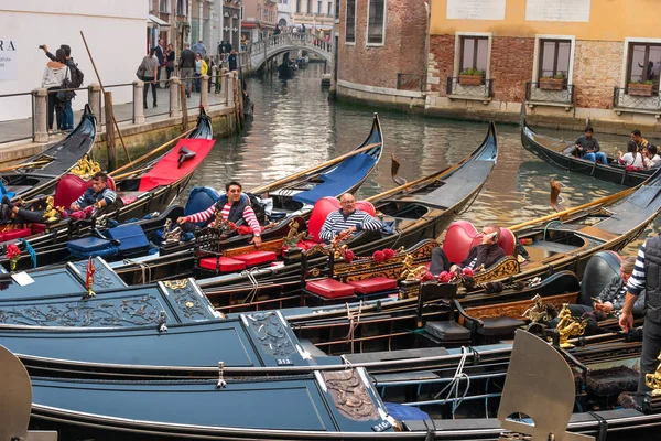 Veneza, Itália - 13 de outubro de 2017: os gondoleiros descansam em suas gôndolas. Os gondoleiros brincam e riem . — Fotografia de Stock