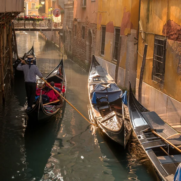 Veneza, Itália - 13 de outubro de 2017: Gondolier transporta turistas através do estreito canal de Veneza . — Fotografia de Stock
