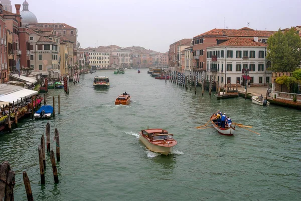 Venecia, Italia - 13 de octubre de 2017: vista del Gran Canal. Barcos, barcos y tranvías fluviales navegan a lo largo del canal. Los pilares de amarre están decorados con adornos a rayas . — Foto de Stock