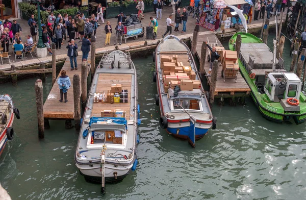 Wenecja, Włochy - 13 października 2017: molo na Canal Grande. Na pierwszy plan rozładunku ładunku łodzi. Na nabrzeże jest namiot z pamiątkami. — Zdjęcie stockowe