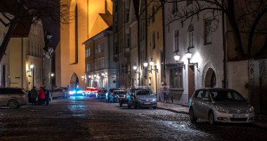 Tallinn, Estonya - 3 Ocak 2020: Tallinn, Estonya 'daki Lai caddesinin gece görüşü. St. Olav kilisesinin girişi görünür.