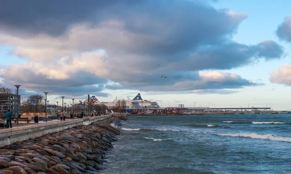 Tallinn, Estland - 4 januari 2020: Utsikt över Tallinns hamn från strandpromenaden längs Pirita Street. Strandpromenaden är förstärkt med granitblock. Färjor dockade i hamnen — Stockfoto