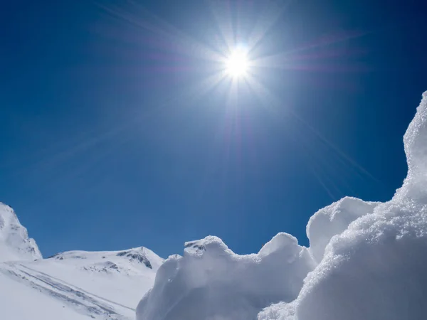 Mavi gökyüzü olan kar duvarı ve güneşli bir günde güneş.