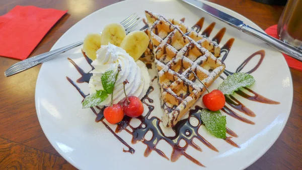 Üstü çikolata, muz, kiraz ve krem şantili waffle..