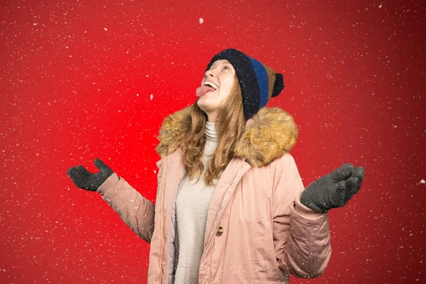 Young woman tries to catch snowflakes with her mouth — Stock Photo, Image