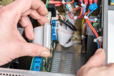 teknisyen bir elektrik cihazının bileşenlerini birleştirir