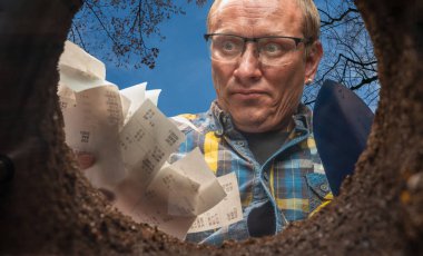 Bir adam makbuzlarını bir deliğe atmak ister.