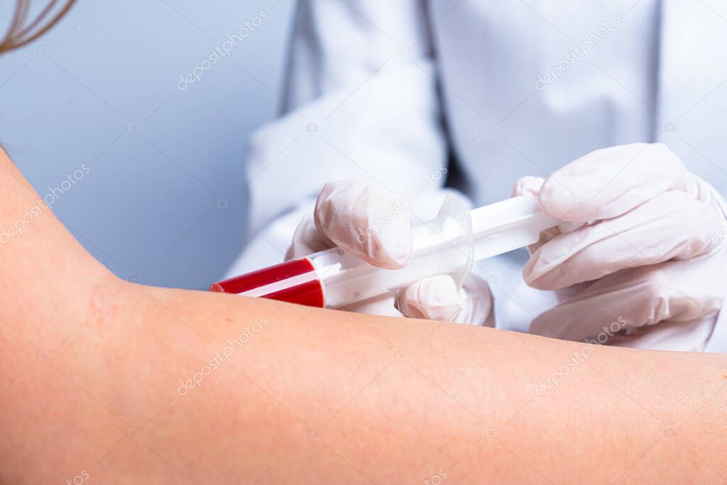 a doctor is taking blood from his patient at the arm