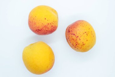 Beyaz arka planda lezzetli, güzel kayısılar var.