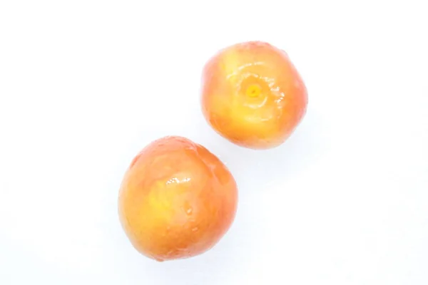 Orange wet tasty plums located on a white background — ストック写真