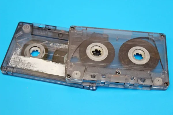 Velhas cassetes de áudio transparentes localizadas em um fundo azul — Fotografia de Stock