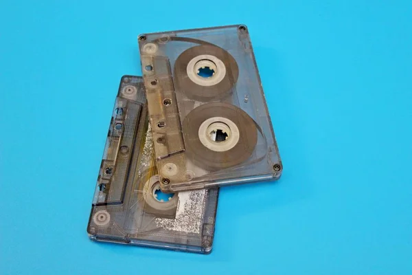 Mavi arkaplanda bulunan eski şeffaf ses kasetleri — Stok fotoğraf
