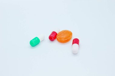 Beyaz arka planda çok renkli haplar bulunur.