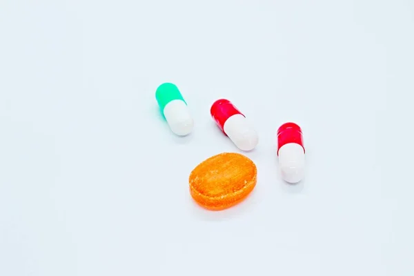 Multi-colored pills are located on a white background — Stock Photo, Image