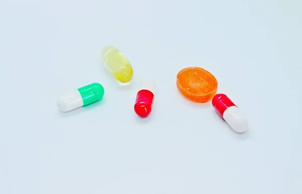 多色の錠剤は白い背景に位置しています — ストック写真