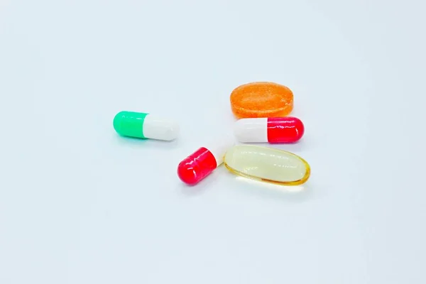 Multi-colored pills are located on a white background — Stock Photo, Image