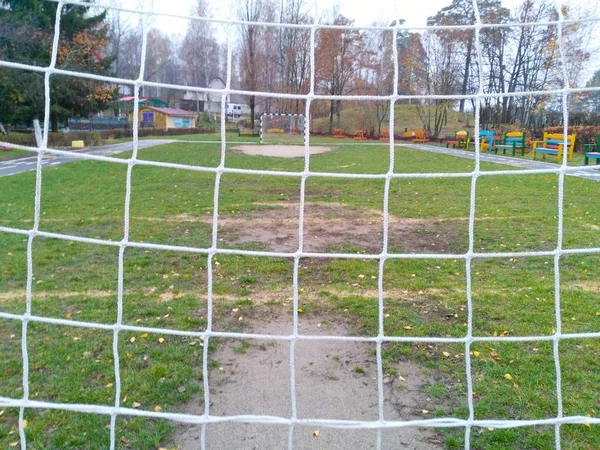 Red de fútbol blanco en el gol de un campo de fútbol —  Fotos de Stock