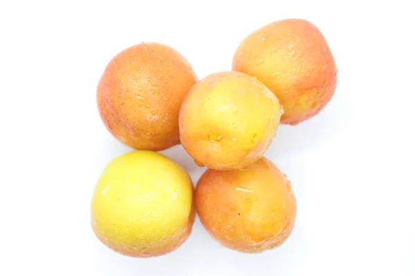 Ripe wet yellow plums located on a white background — Stock Photo, Image