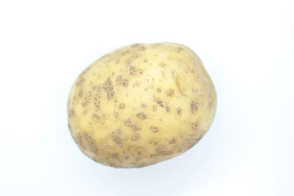 Potato tuber perched on a white background