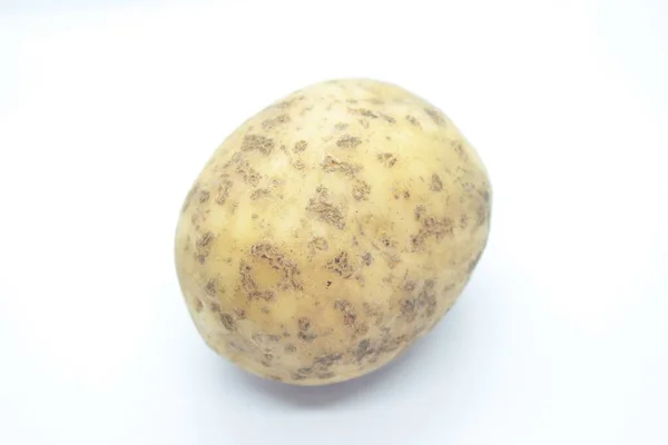Potato tuber perched on a white background