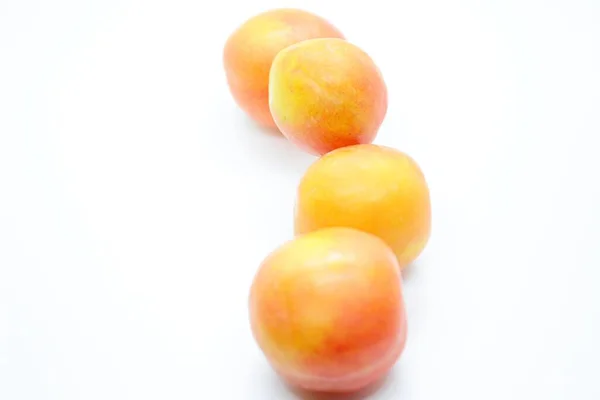 Ripe orange plums perched on a white background — Stock Photo, Image