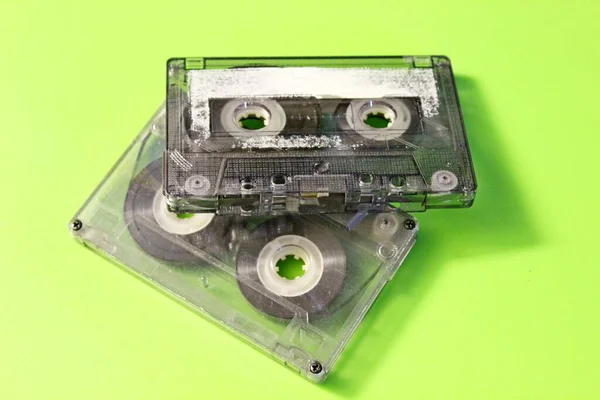 Old audio cassettes are located on a green background