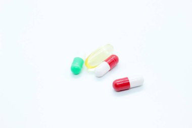 Tabletler, kapsüller, vitaminler, beyaz arka planda yer almaktadır.