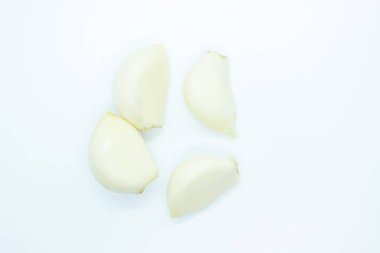 Beyaz arka planda soyulmuş sarımsak karanfilleri