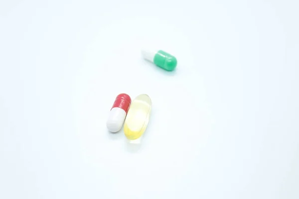 Comprimidos, cápsulas, vitaminas, localizados num fundo branco — Fotografia de Stock