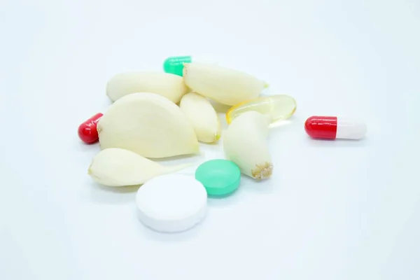 Knoflook en vitaminen bevinden zich op een witte achtergrond — Stockfoto