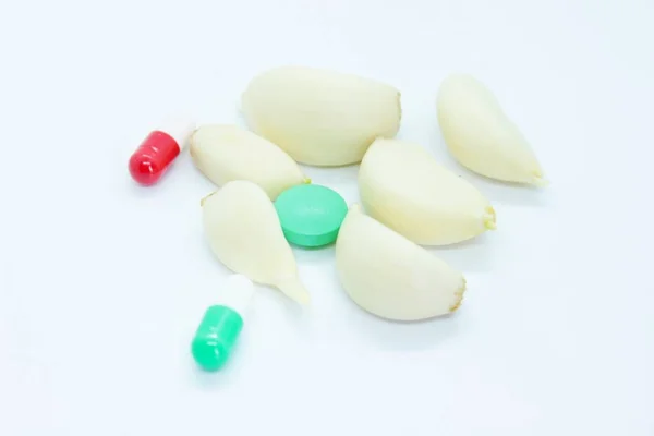 Σκόρδο και βιταμίνες βρίσκονται σε λευκό φόντο — Φωτογραφία Αρχείου